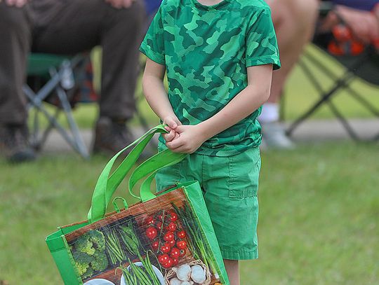 A young parade goer eagerly awaits his share of the goodies tossed out along the mile long route