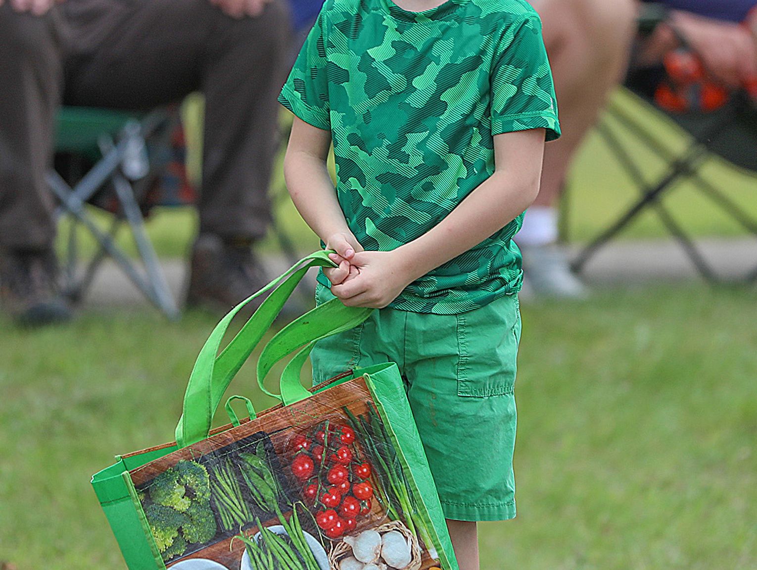 A young parade goer eagerly awaits his share of the goodies tossed out ...