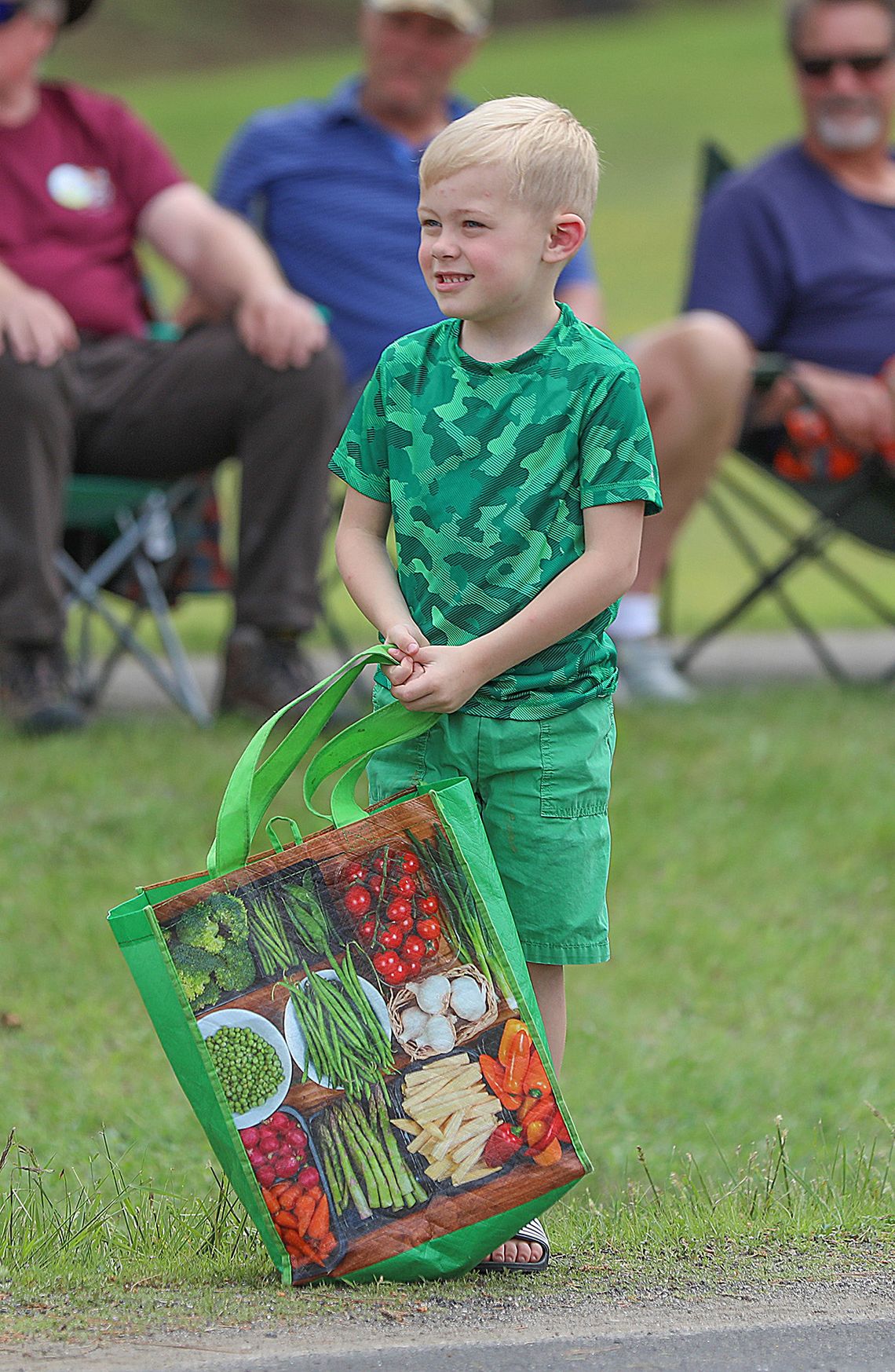 A young parade goer eagerly awaits his share of the goodies tossed out along the mile long route